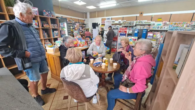 Les marcheurs partagent un café chaud autour d'une petite table à la fin de la balade.